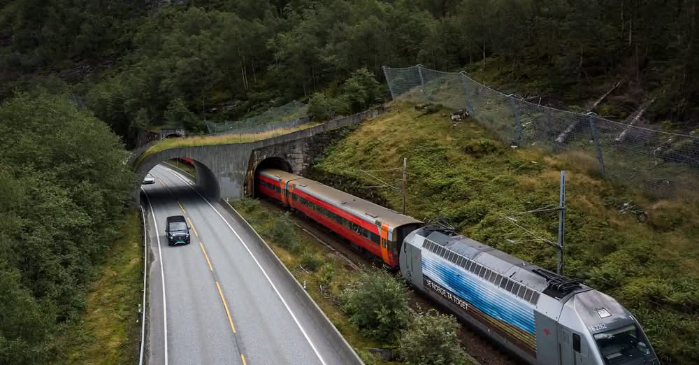 Tog og veg langs fjellsida